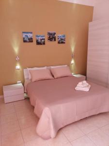 una camera da letto con un grande letto con lenzuola rosa di Amasté in Puglia CASA VACANZA a Bisceglie