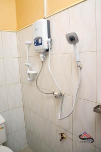 a shower in a bathroom with a hand dryer on a wall at Kica Apartment with Airconditioned bedrooms in Lira, Uganda in Lira