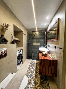a bathroom with a sink and a washing machine at Pearl House in Hydra +34 photos