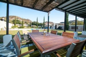 a wooden table and chairs on a patio at Villa Olympos Ladiko in Kalithies