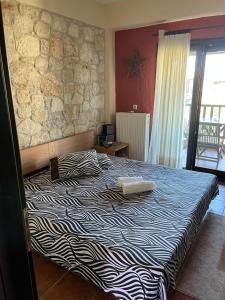 a bed in a room with a stone wall at Afytos house in Afitos