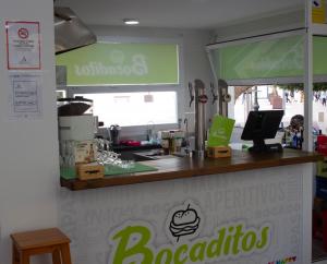 a coffee shop with a counter with a sign on it at Be Happy Hostel in Nerja