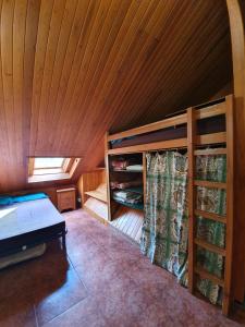 a room with a bed and a wooden ceiling at Albergue "El Aguila" in Candanchú