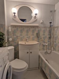 a bathroom with a toilet and a sink and a mirror at Przytulny apartament blisko MOLO GIŻYCKO in Giżycko