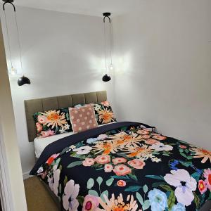 a bedroom with a bed with a floral comforter at Alexandra Park in Manchester