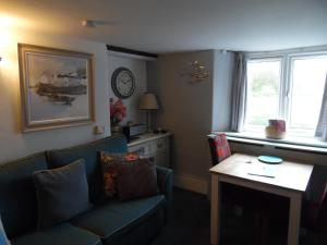 a living room with a couch and a table at Langdon Farm Cottage in Boyton