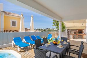 a patio with a table and chairs on a deck at Casa da Amoreira in Alvor