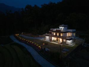 a large house is lit up at night at The Chirpy Bungalow By LUHO Leisure in Dehradun