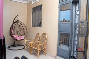 a pair of chairs and a swing on a porch at Kica Apartment with Airconditioned bedrooms in Lira, Uganda in Lira