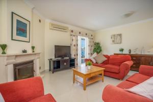a living room with a red couch and a tv at Casa da Amoreira in Alvor