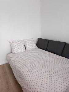 een bed met twee kussens in een kamer bij Appartement proche PARIS/STADE DE FRANCE in Épinay-sur-Seine
