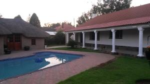 une maison avec une piscine dans la cour dans l'établissement Magnolia Guesthouse & coffeeshop, à Vaalpark
