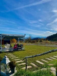 un cenador con mesa y sillas en un campo en Domek w górach Tiny House Forest Jacuzzi/widoki, en Lipnica Wielka