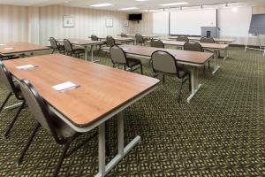 ein Klassenzimmer mit Tischen, Stühlen und einem Bildschirm in der Unterkunft Baymont by Wyndham Indianapolis South in Indianapolis