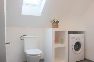 een badkamer met een toilet en een wasmachine bij LE SUNNY, Mulhouse centre in Mulhouse