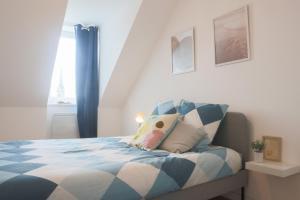 een slaapkamer met een blauw en wit bed en een raam bij LE SUNNY, Mulhouse centre in Mulhouse