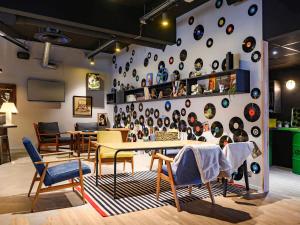 a room with tables and chairs and a wall with plates at Mercure Reims Parc Des Expositions in Reims