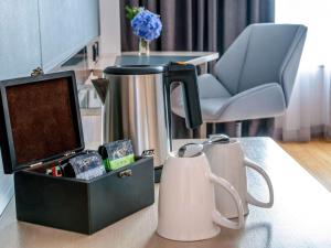 a table with a coffee maker and a chair at Novotel Bangkok on Siam Square in Bangkok