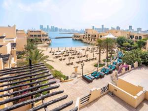 an aerial view of a beach with chairs and tables at Novotel Bahrain Al Dana Resort in Manama