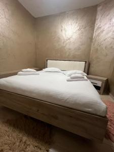 a large bed with white sheets and pillows on it at Pensiunea Pelican in Tulcea