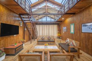 Hotel Wood Winds - Best Hotel in Chail في شيملا: غرفة معيشة بجدران خشبية ونور علوي