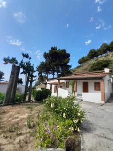 ein Haus an der Seite eines Hügels mit Bäumen in der Unterkunft Villaggio Marina Del Capo Capo Vaticano in Ricadi