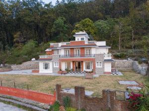 una casa grande en medio de un patio en The Chirpy Bungalow By LUHO Leisure en Dehradun