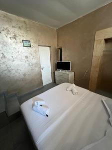 a bedroom with a bed with two towels on it at Pensiunea Pelican in Tulcea