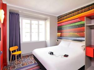 um quarto de hotel com uma cama com um par de auscultadores em ibis Styles Lille Centre Grand Place em Lille