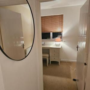 einen Spiegel in einem Zimmer mit einem Schreibtisch und einem Fenster in der Unterkunft Alexandra Park in Manchester