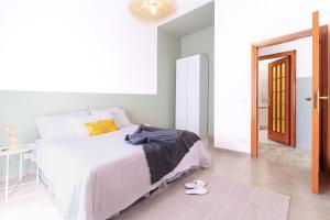biała sypialnia z łóżkiem i żyrandolem w obiekcie Ohana holidayhome w mieście Agerola