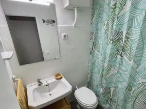 Un baño con lavabo, inodoro y cortina de ducha. en Loft con vistas al Mar en Costa Brava, en Santa Cristina d'Aro