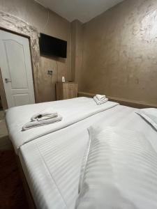 two beds in a room with two towels on them at Pensiunea Pelican in Tulcea