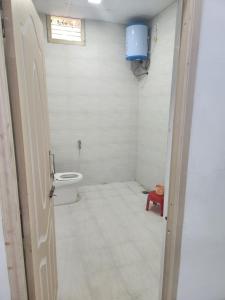 a small bathroom with a toilet and a window at Amaravathi farm stay in Arakkonam