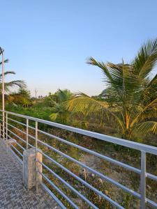 a metal fence with palm trees in the background at Amaravathi farm stay in Arakkonam