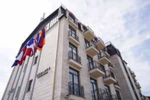 un edificio con dos banderas encima en Hotel Dynasty en Ereván