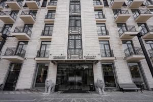 Um edifício com dois leões à frente. em Hotel Dynasty em Yerevan