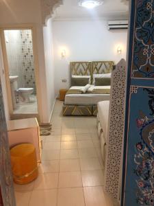 a bedroom with a bed and a bathroom at Riad Malak in Meknès