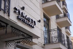 um sinal para um hotel na lateral de um edifício em Hotel Dynasty em Yerevan