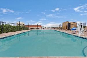 une grande piscine d'eau bleue dans l'établissement Days Inn & Suites by Wyndham Santa Rosa, NM, à Santa Rosa