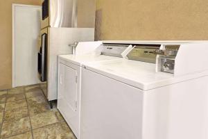 eine weiße Küche mit einem Kühlschrank und einem Geschirrspüler in der Unterkunft Days Inn & Suites by Wyndham Santa Rosa, NM in Santa Rosa