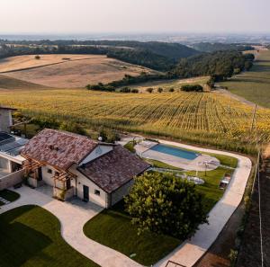 an aerial view of a house with a pool and a vineyard at Il Viaggio Impresa Sociale in Bicchignano