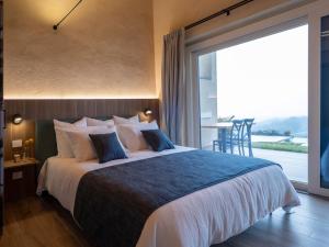 a bedroom with a large bed with a large window at Il Viaggio Impresa Sociale in Bicchignano