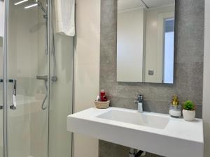 łazienka z białą umywalką i prysznicem w obiekcie Elegante apartamento en Jardines de Montesolana w mieście Los Dolses
