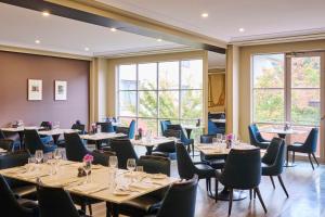 a dining room with tables and chairs and windows at Hyatt Hotel Canberra - A Park Hyatt Hotel in Canberra