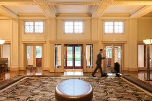 un hombre caminando por un vestíbulo con una mesa en Hyatt Hotel Canberra - A Park Hyatt Hotel, en Canberra