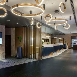 a lobby with a reception desk and chandeliers at NH Berlin Kurfürstendamm in Berlin