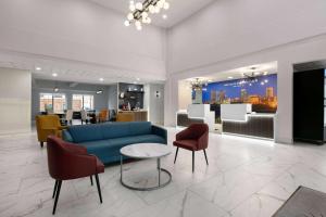 ein Wohnzimmer mit einem blauen Sofa und Stühlen in der Unterkunft La Quinta Inn & Suites by Wyndham Ft Worth-Burleson in Burleson