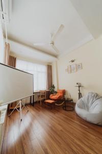 a living room with a flat screen tv and a couch at HeHe Homestay Hanoi in Hanoi