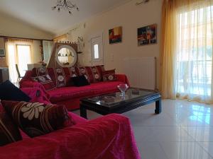 una sala de estar con 2 sofás rojos y una mesa. en One with nature en Kavala